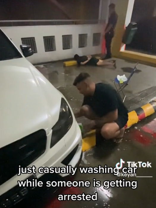 Sg man continues to wash car calmly as another man gets arrested at car park