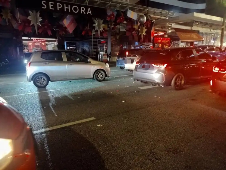 Cars driving over rubbish on the road after new year celebration in kl