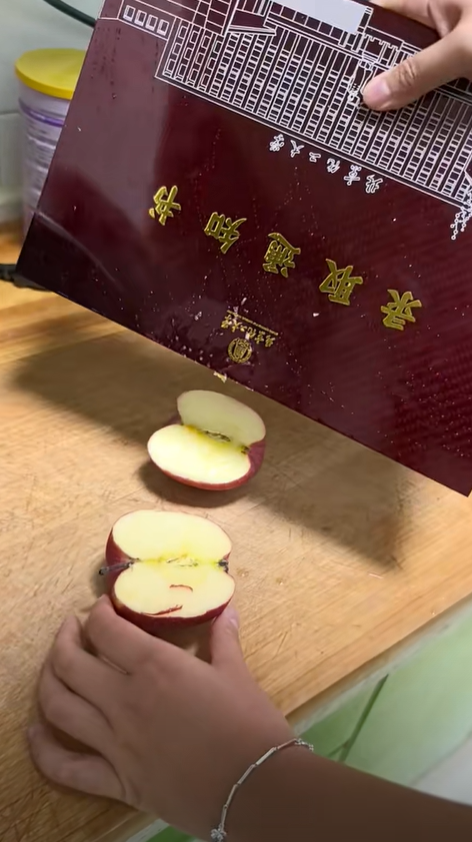 China student using admission letter to cut apple