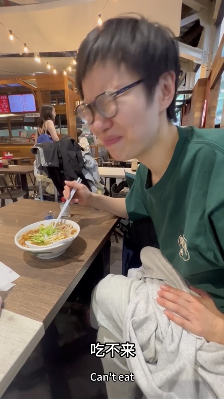 China woman makes a face after eating asam laksa