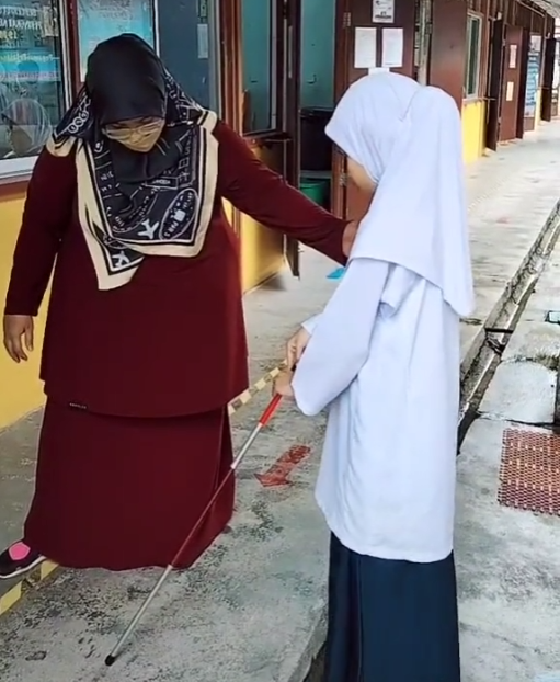Teacher helping visually impaired student
