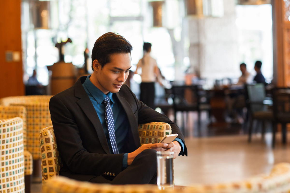 Man in suit holding his phone