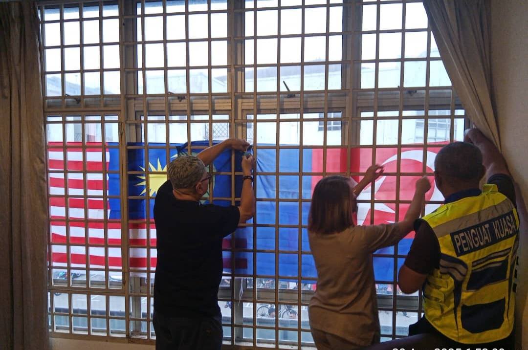 Dental clinic staff correcting upside down Jalur Gemilang