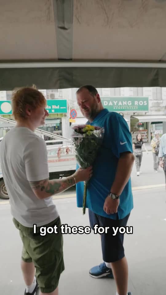 Ed sheeran giving flowers to his guide