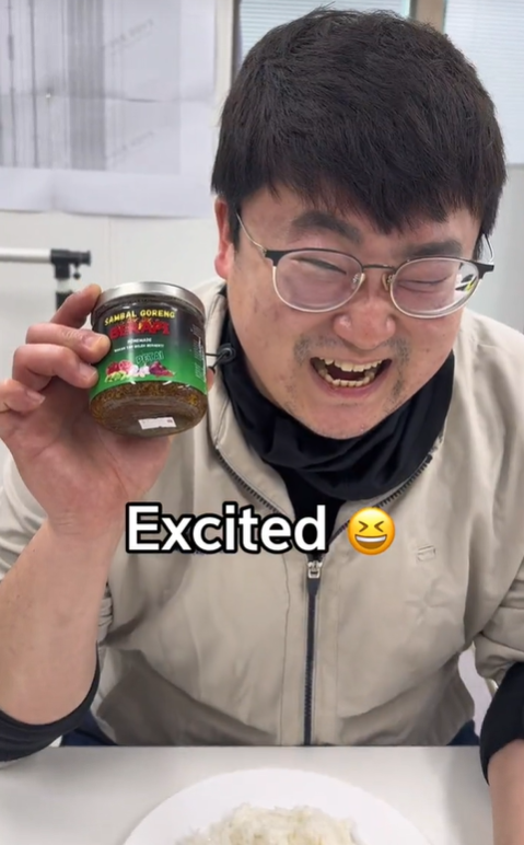 Excited korean man with a bottle of sambal