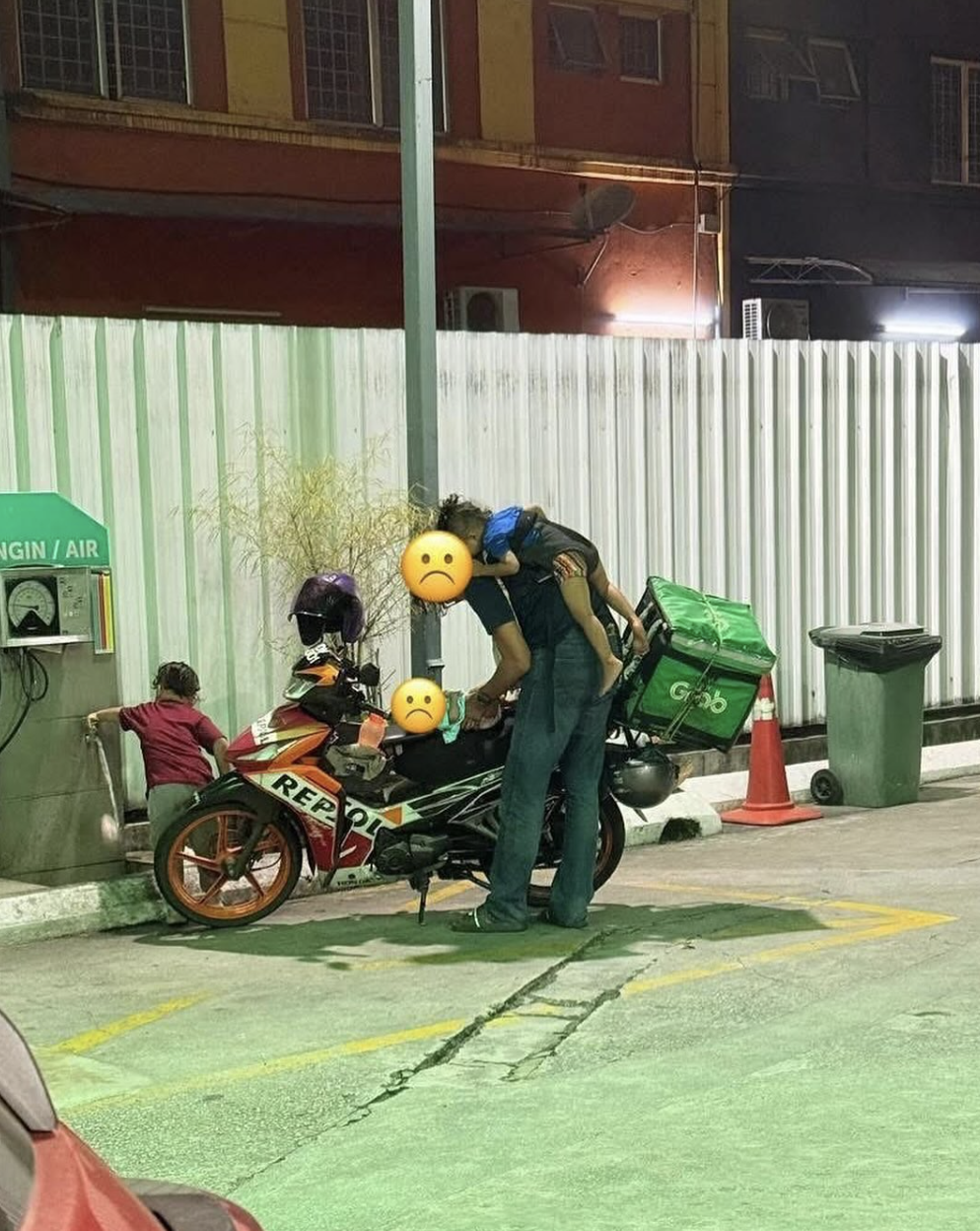 Father of 3 changing diaper at petrol station