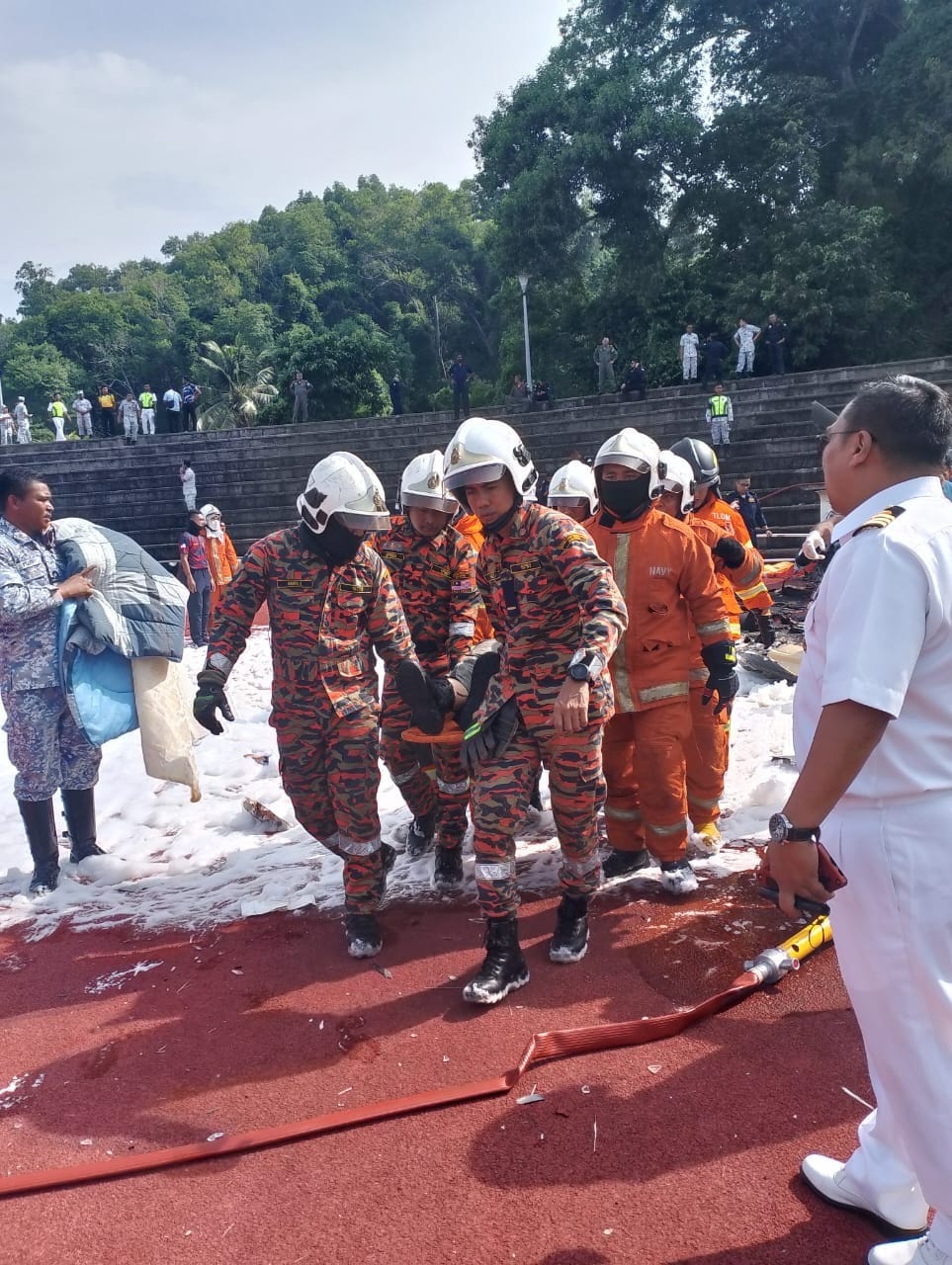 Firemen carrying body of lumut helicopter crash victim