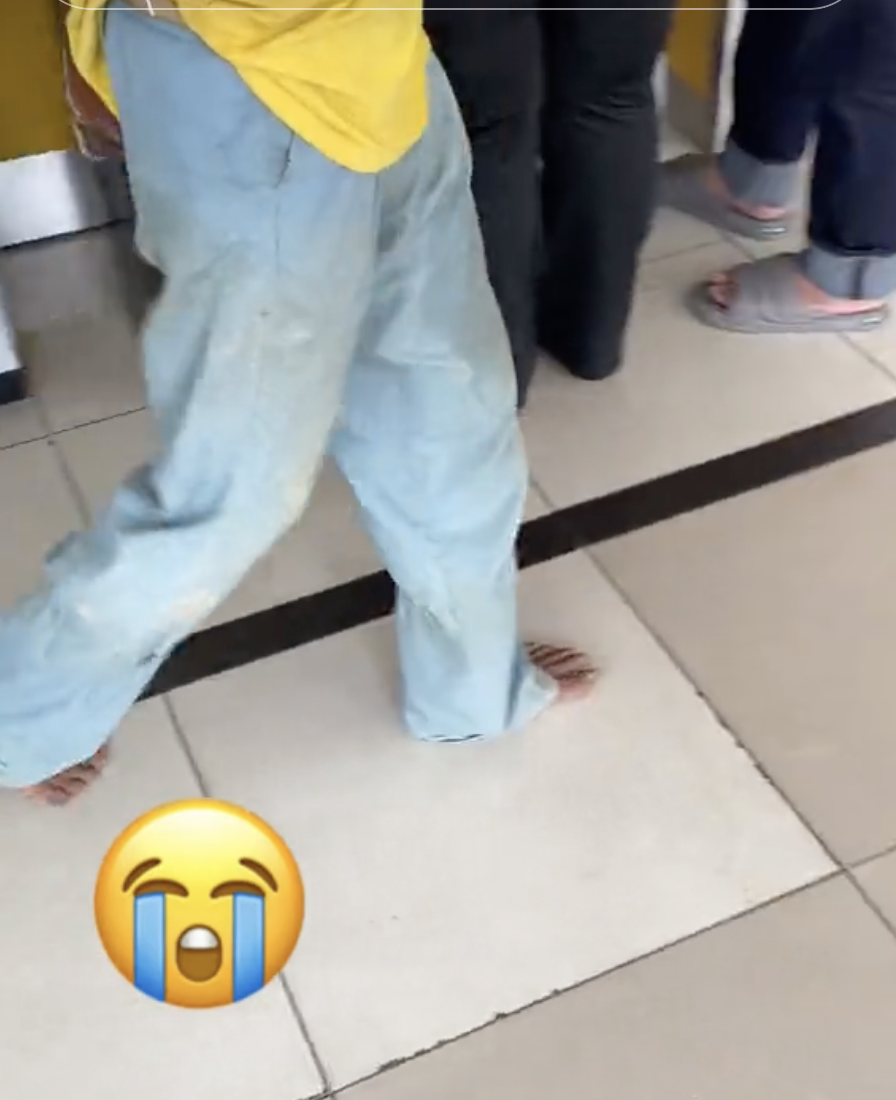 Foreign worker removes shoes at atm 02