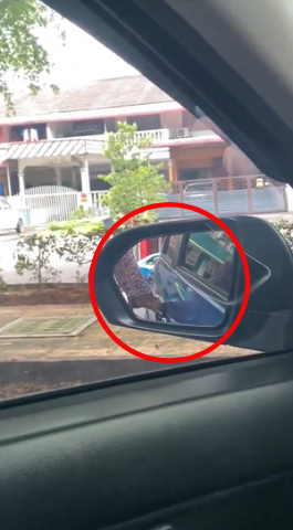 Foreigner's hand seen tugging at door handle of parked car in banting