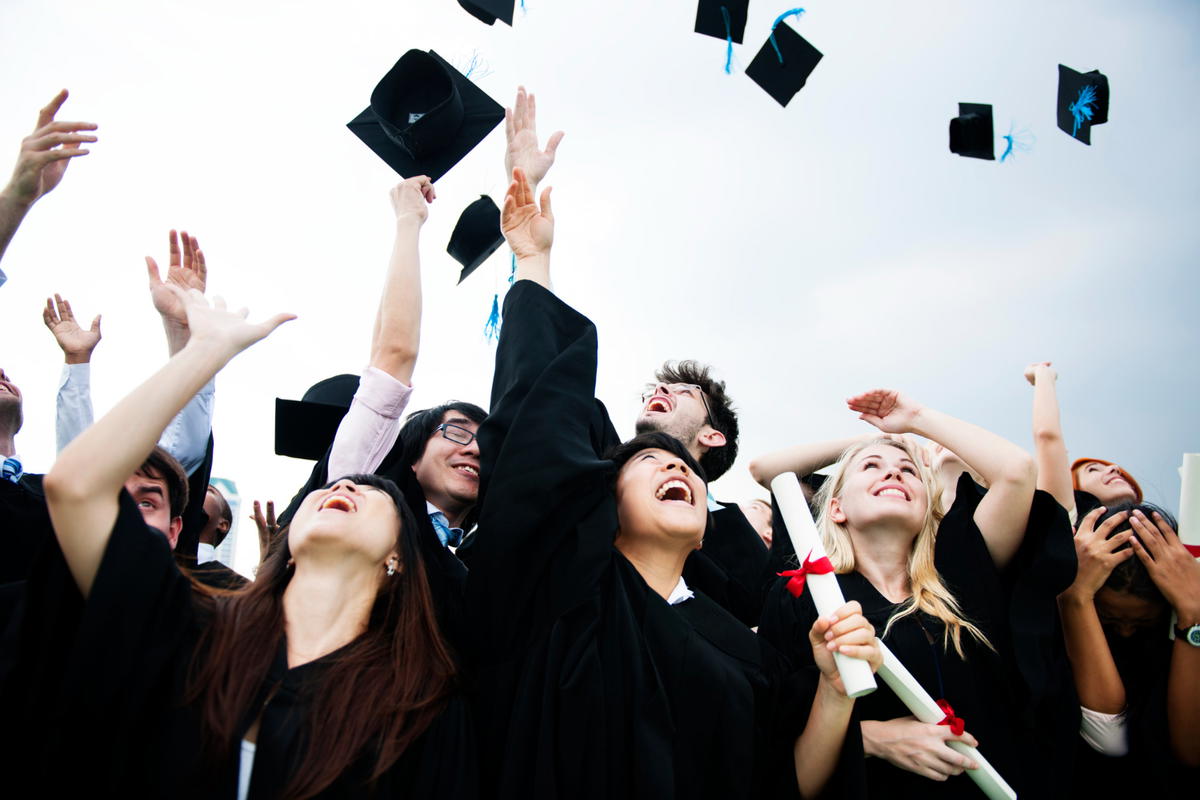 Group-diverse-grads-throwing-caps-up-sky