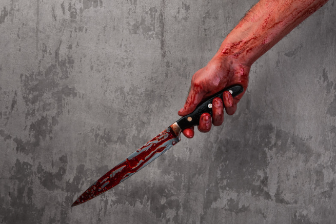 Hand holding bloodied knife