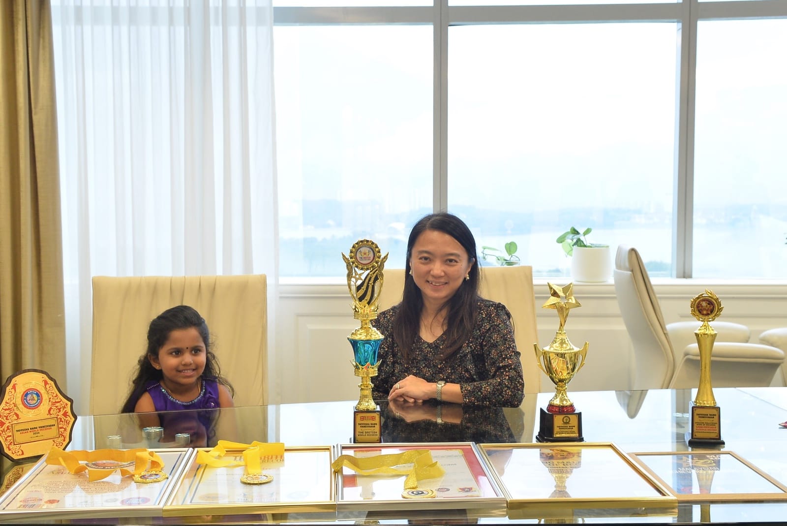 Hanna yeoh sitting with thevissha along with her five world record