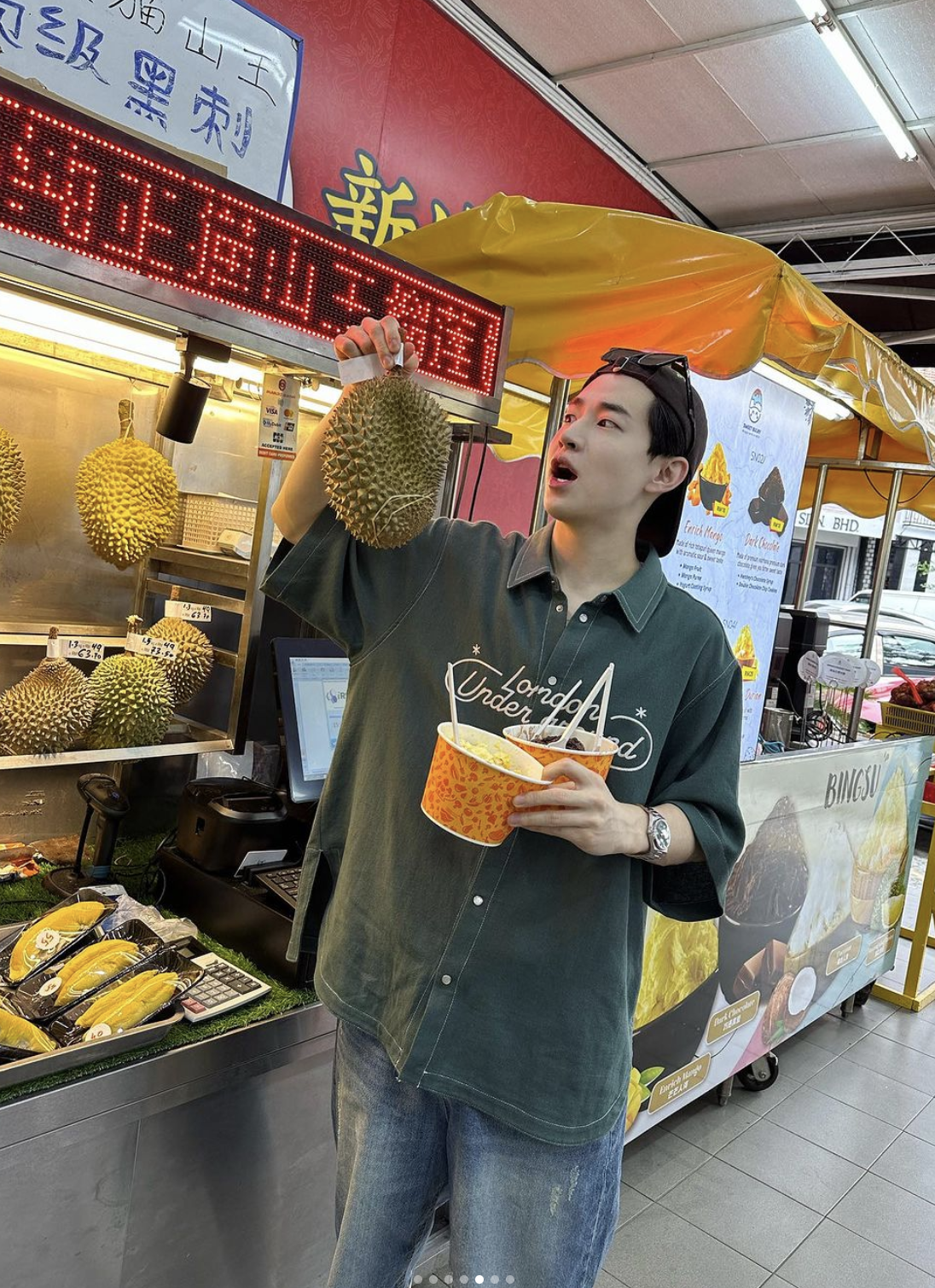 Henry lau in petaling street posing with a musang king durian