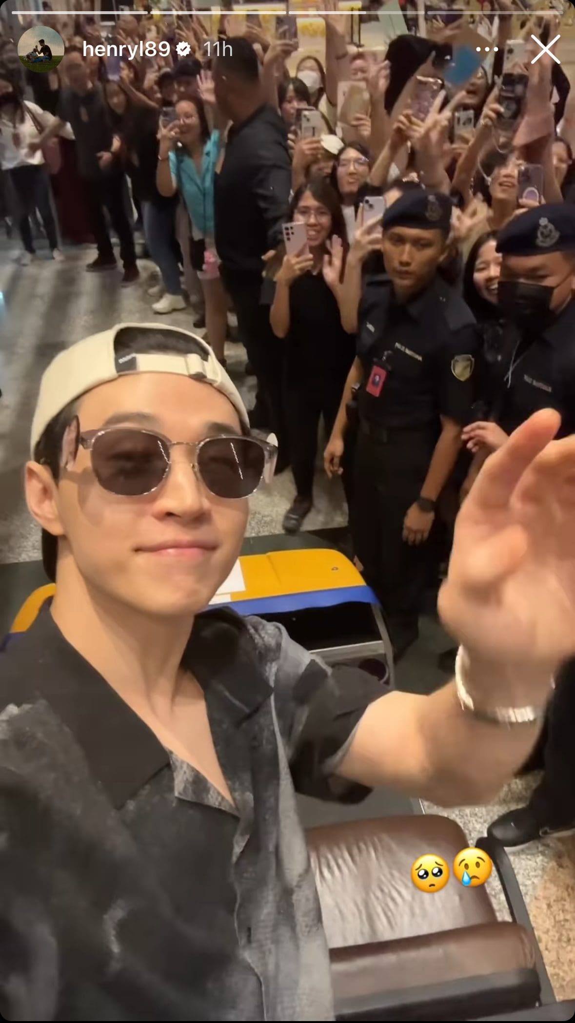 Henry Lau waves at his fans at KLIA