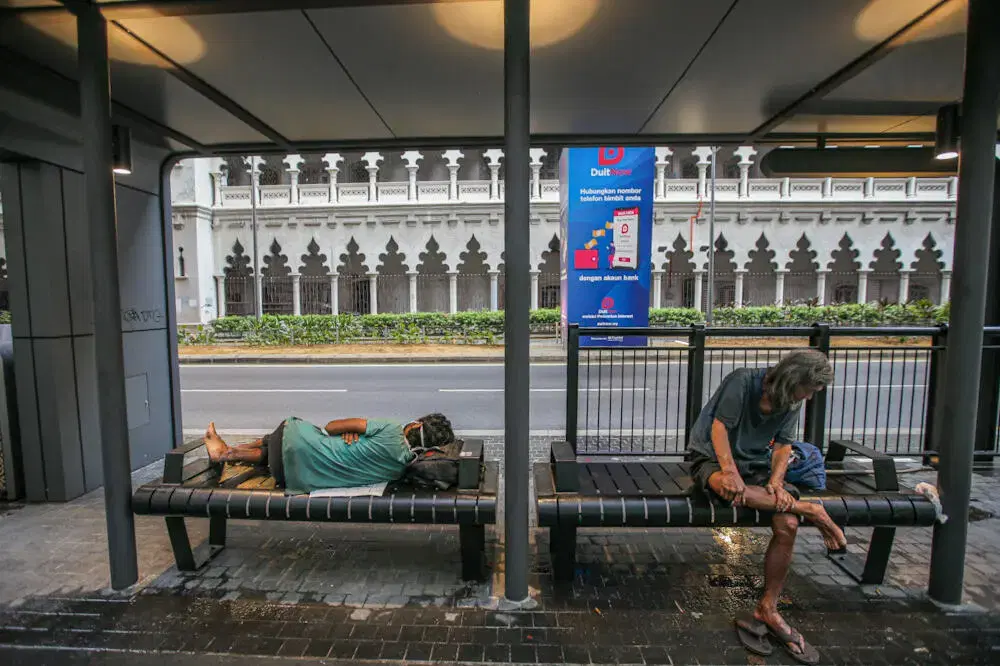 Homeless men sleeping at bus stop in KL