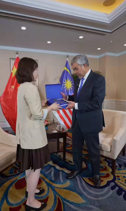 Husna handing over gift to zahid