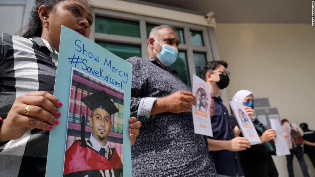 Nus graduate holds up sign supporting the abolishment of death penalty during convocation | weirdkaya