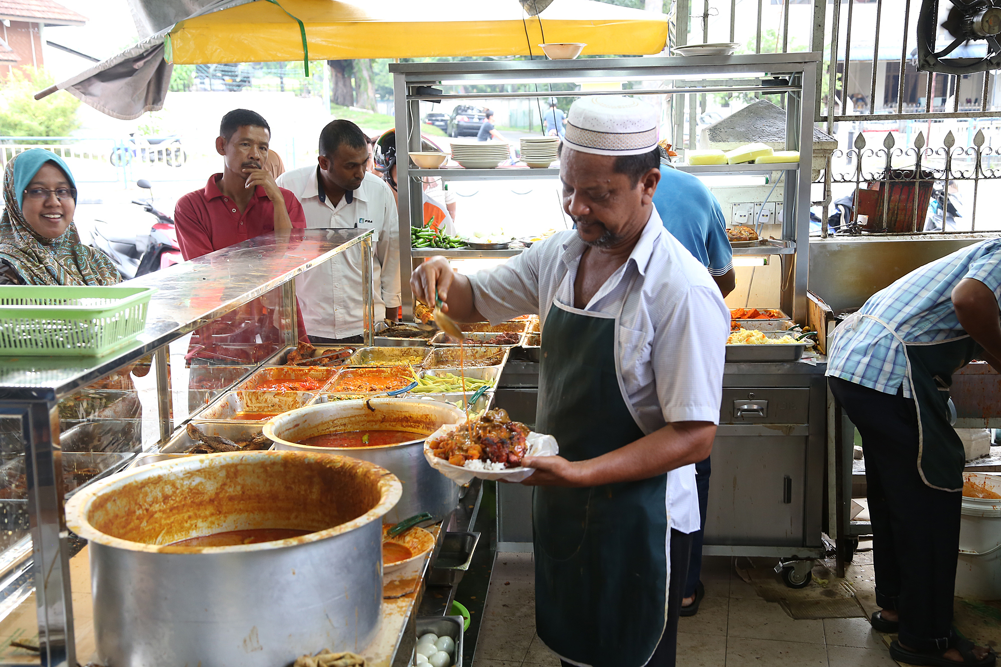 Deen maju nasi kandar restaurant, penang - staff preparing a customised nasi kandar for customers
