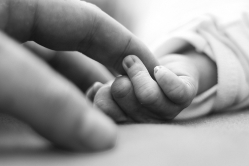 Woman holding baby's hand