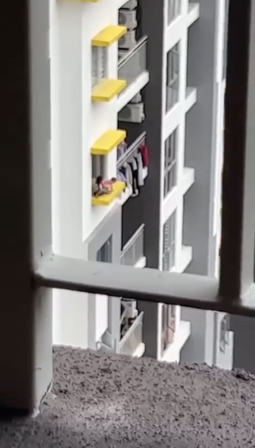 Kids playing on windowsill of high-rise condo in kl