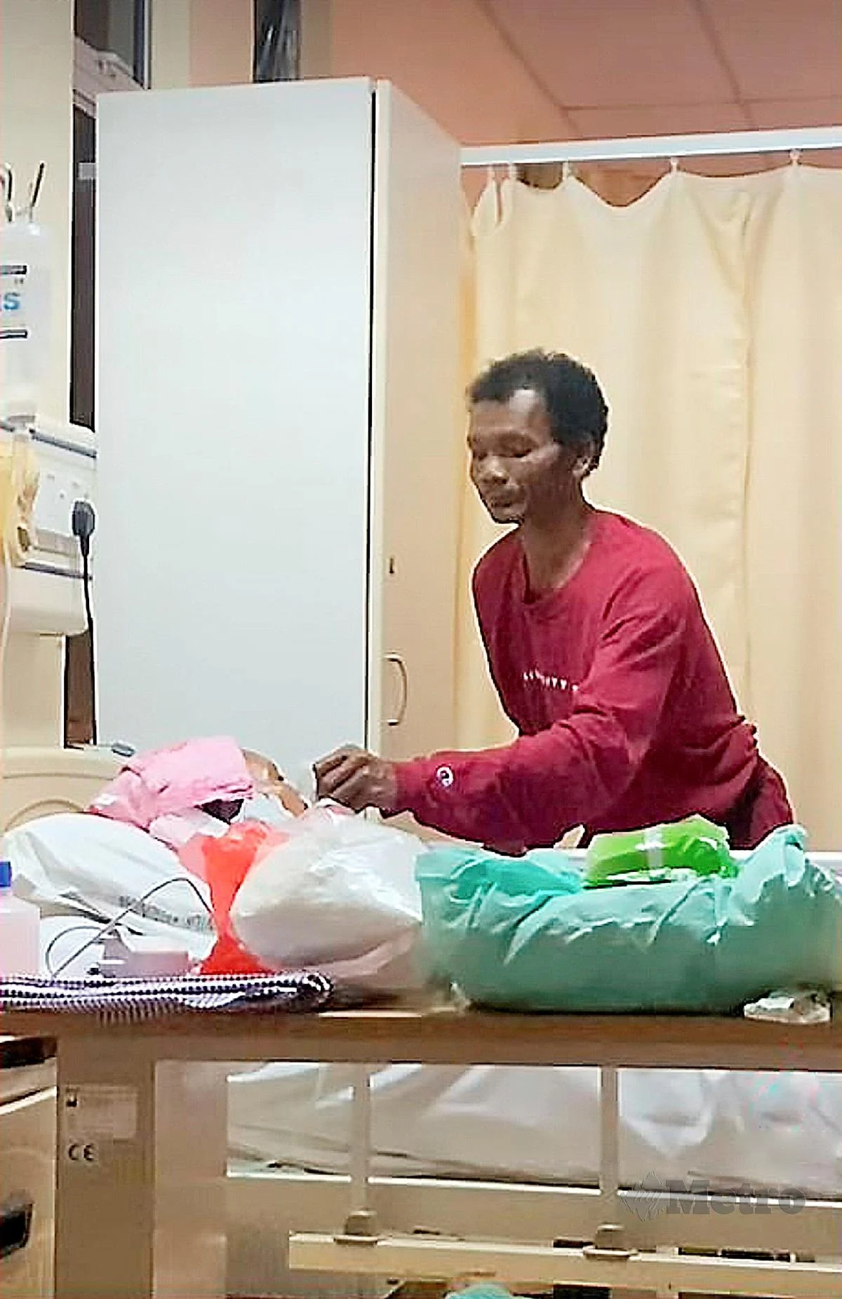 Despite his wife being in a coma for the past two months, an orang asli man from gua musang, kelantan, remains hopeful that she will recover and has not lost faith in her ability to overcome the illness.