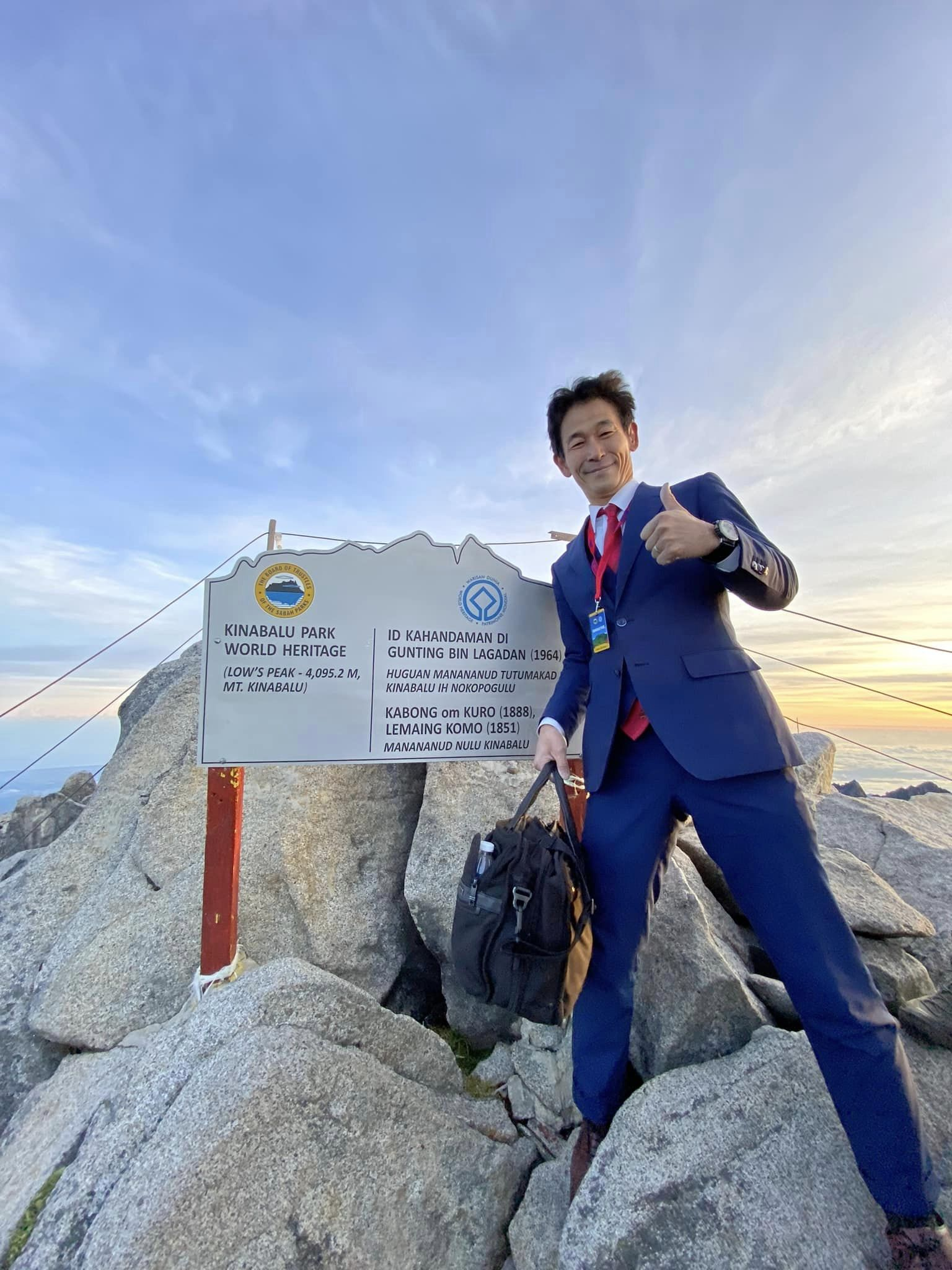 Japanese man climbs mt kinabalu in a suit to attend 'business meeting'