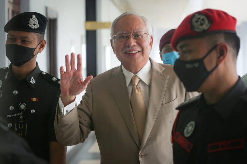 Najib Razak waves at photographer