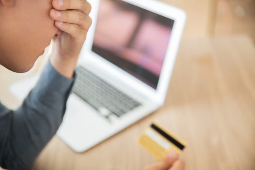 Depressed man holding a credit card