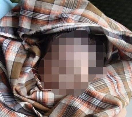 The newborn baby boy covered in scarf or kain pelikat