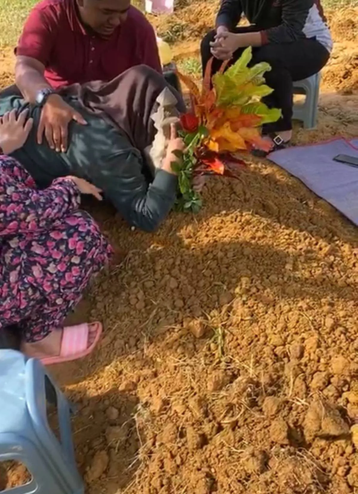 M'sian girl bids father goodbye by hugging his grave as she was unable to buy bus tickets to attend his burial