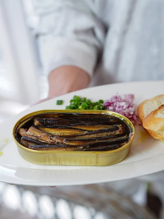 Man serves tinned sardines