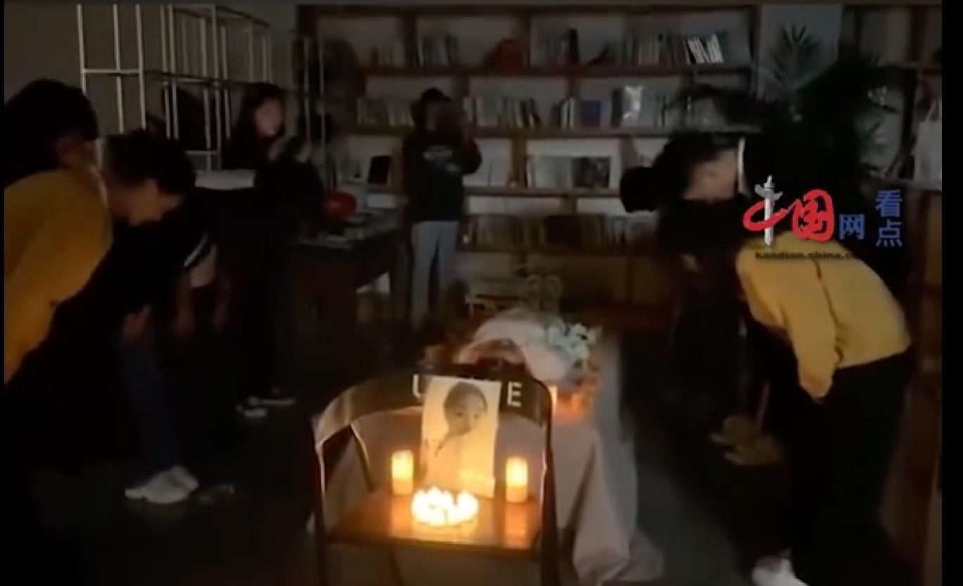 China woman's friends bow and give white flowers at her 'funeral'