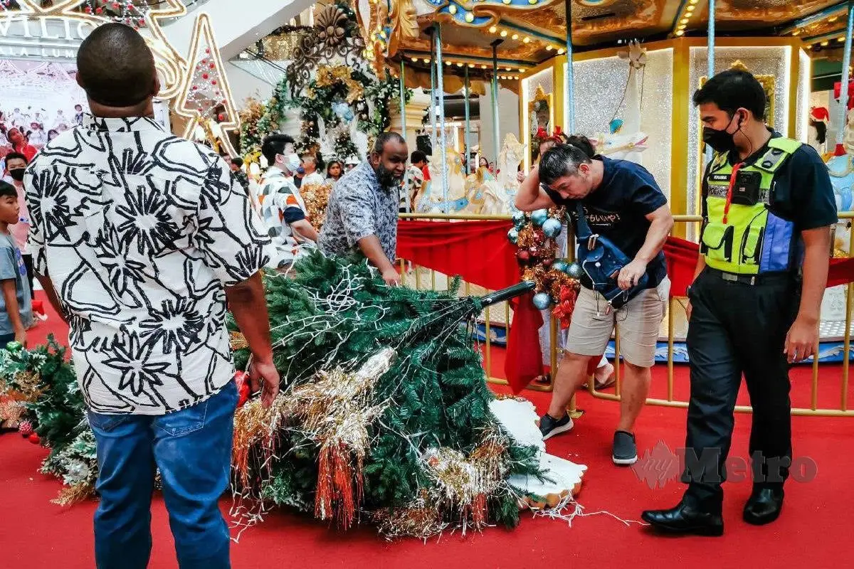 Shoppers gather around sg man who was injured after christmas tree at pavilion kl falls on his head