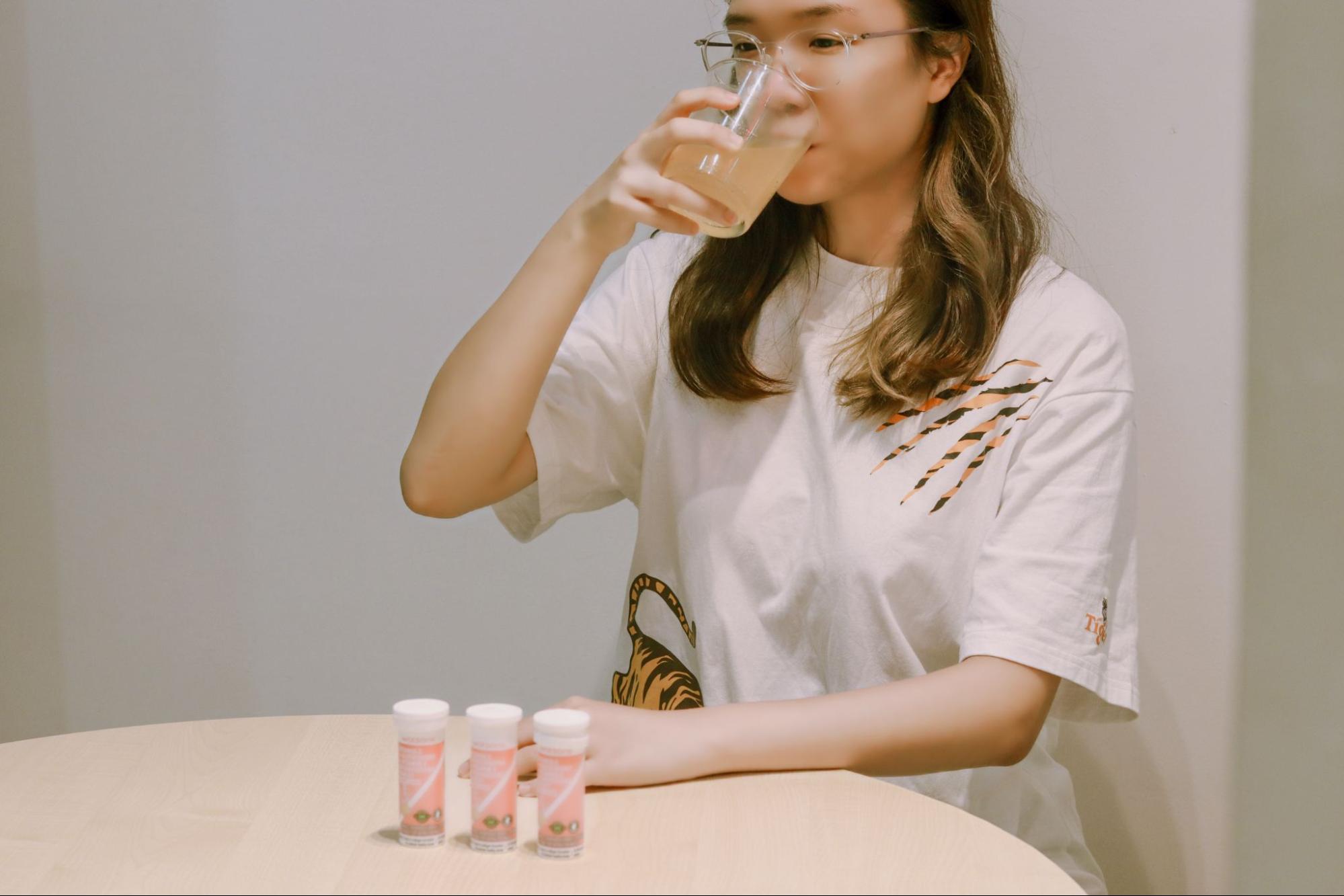Asian woman consuming vitamins from watsons
