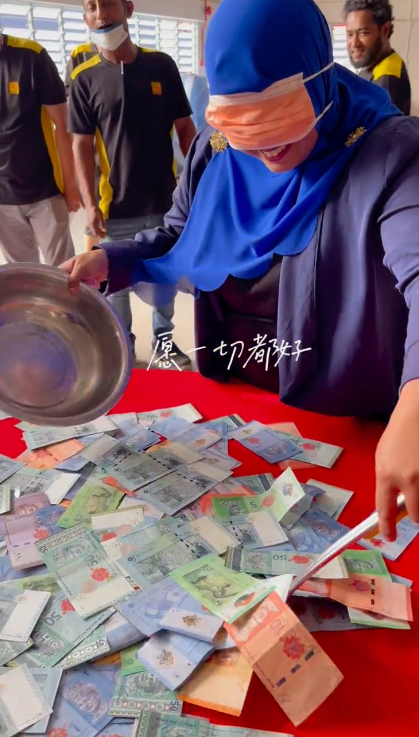 Malaysian stuff blindfolded, ready to scoop some cash on the table for cny