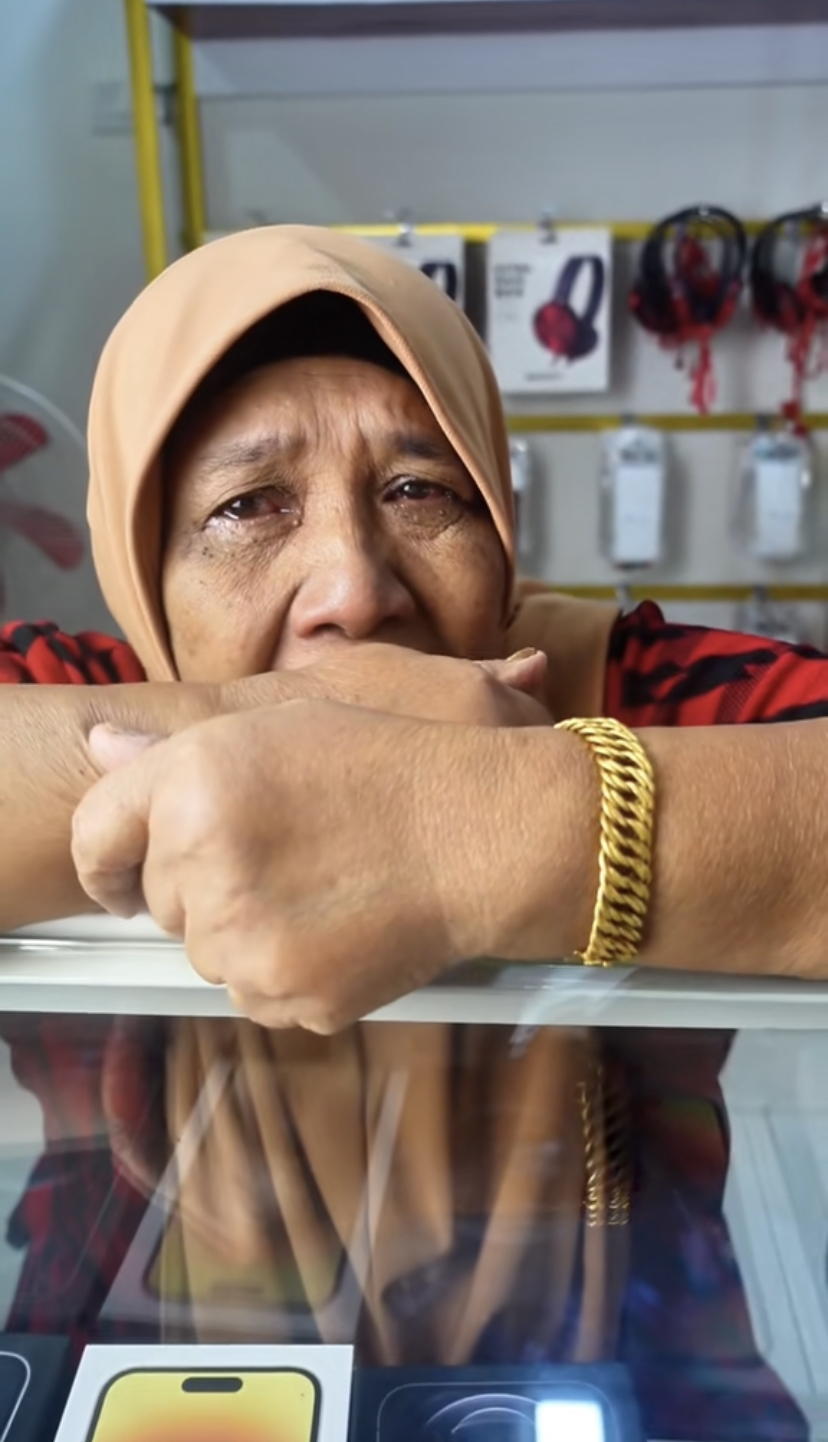 Malaysian mother with watery eyes explaining why she had to sell her gold bracelet