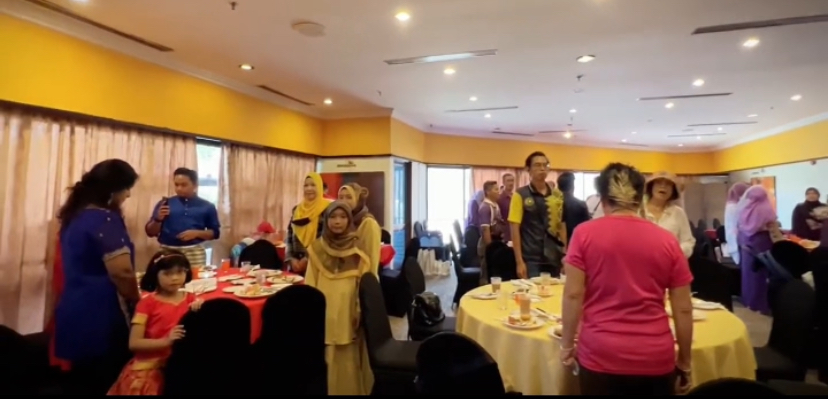 Diners at malaysia restaurant standing and singing negaraku