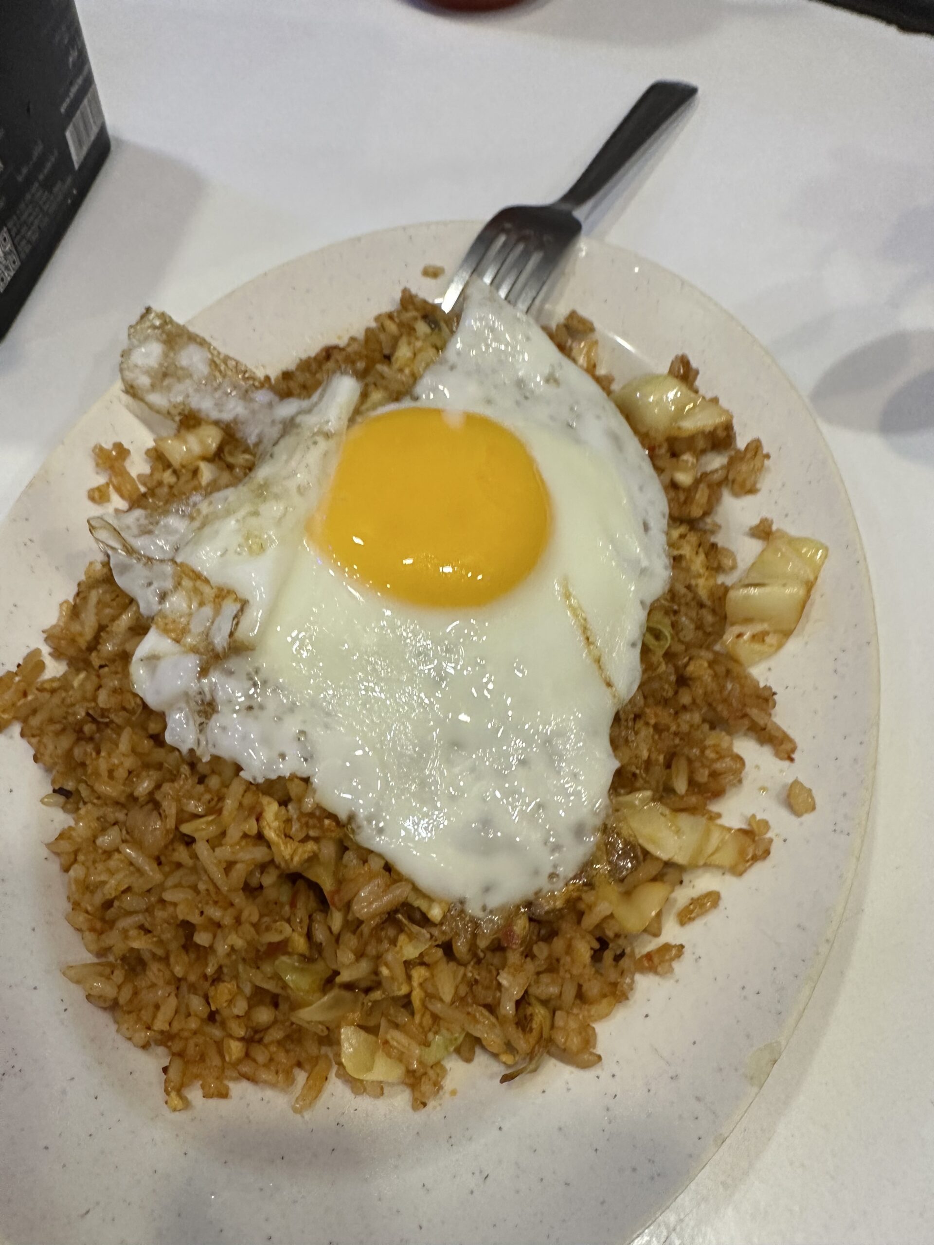 Fried rice with half cooked egg on top.