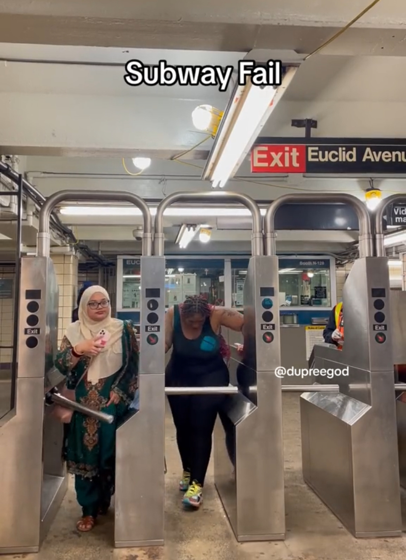 Muslim woman and american at the subway's turnstile