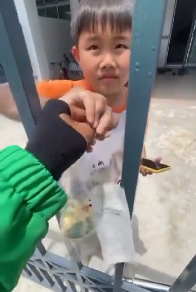 Grab rider handing in food to chinese kid