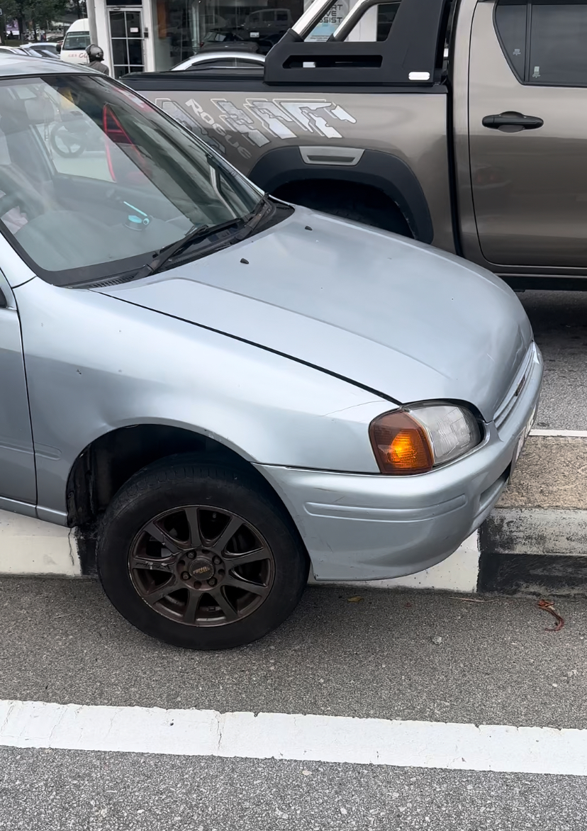 Car stuck on road divider