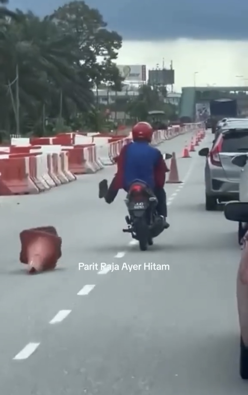 Motorcyclist continues to kick the cones at the side out of boredom