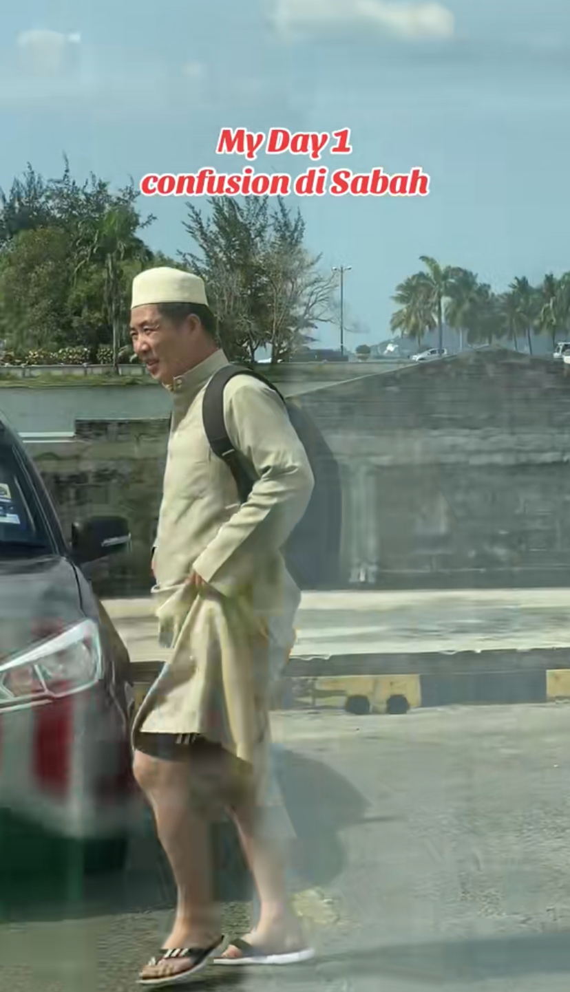 Tourist in white 'jubah' coming back from visiting masjid at sabah