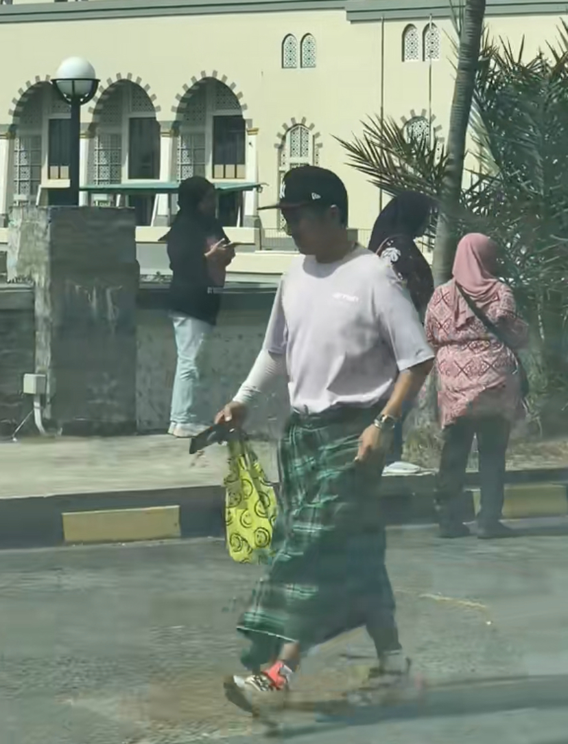 Tourist in 'kain pelikat' coming back from visiting masjid at sabah