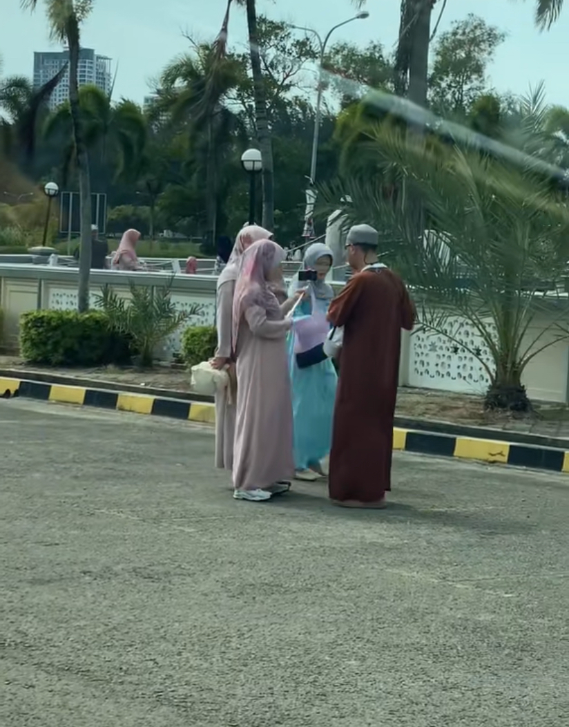 A bunch of tourists with their selfie stick at masjid in sabah