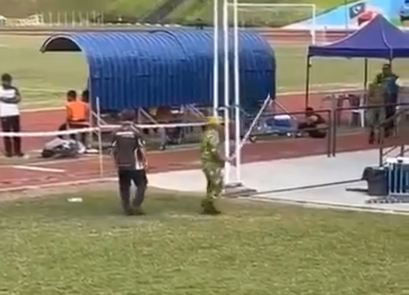 Rela takes the iron rod from a man at football match