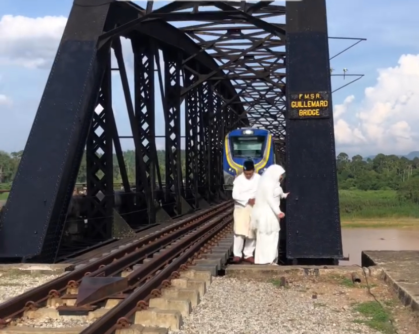 M'sian couple blocks ktm train's path during photoshoot at guillemard bridge in kelantan