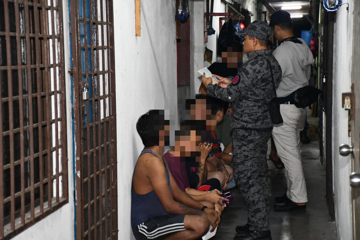 Immigration officer checking on illegal workers during Ops Sapu