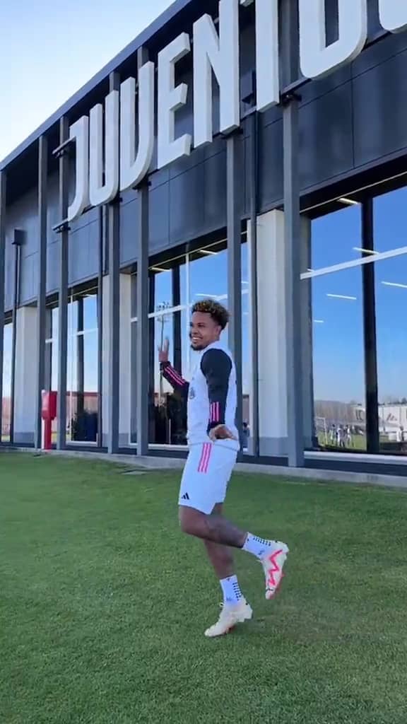 Juventus player standing infront of his football team building