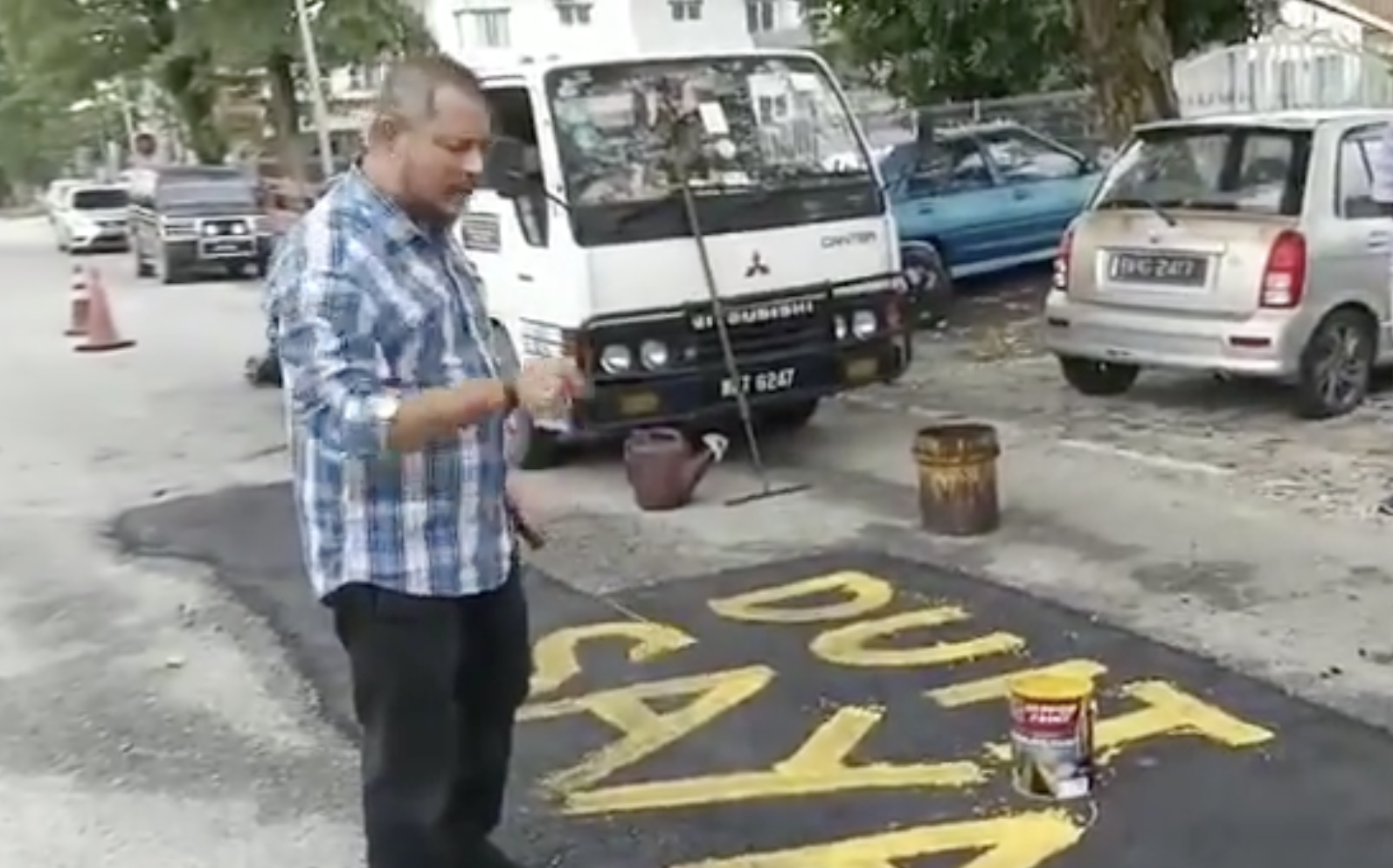 Klang man writes 'my money' on potholes he fixed 02